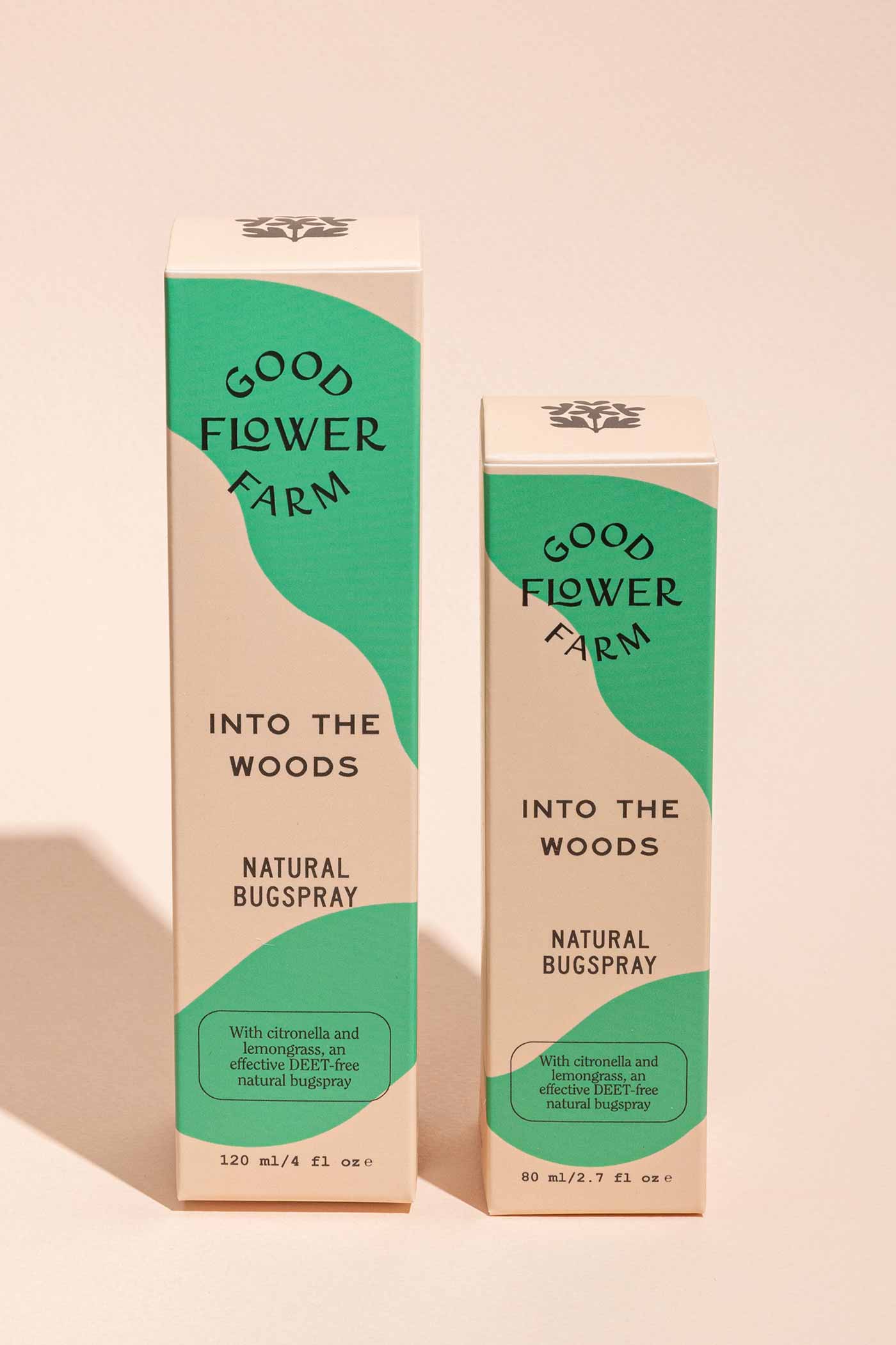 Two boxes of Good Flower Farm Into the Woods Natural Bugspray in green and beige packaging, each a different size. Citronella and essential oils are highlighted, offering an effective organic insect repellent.
