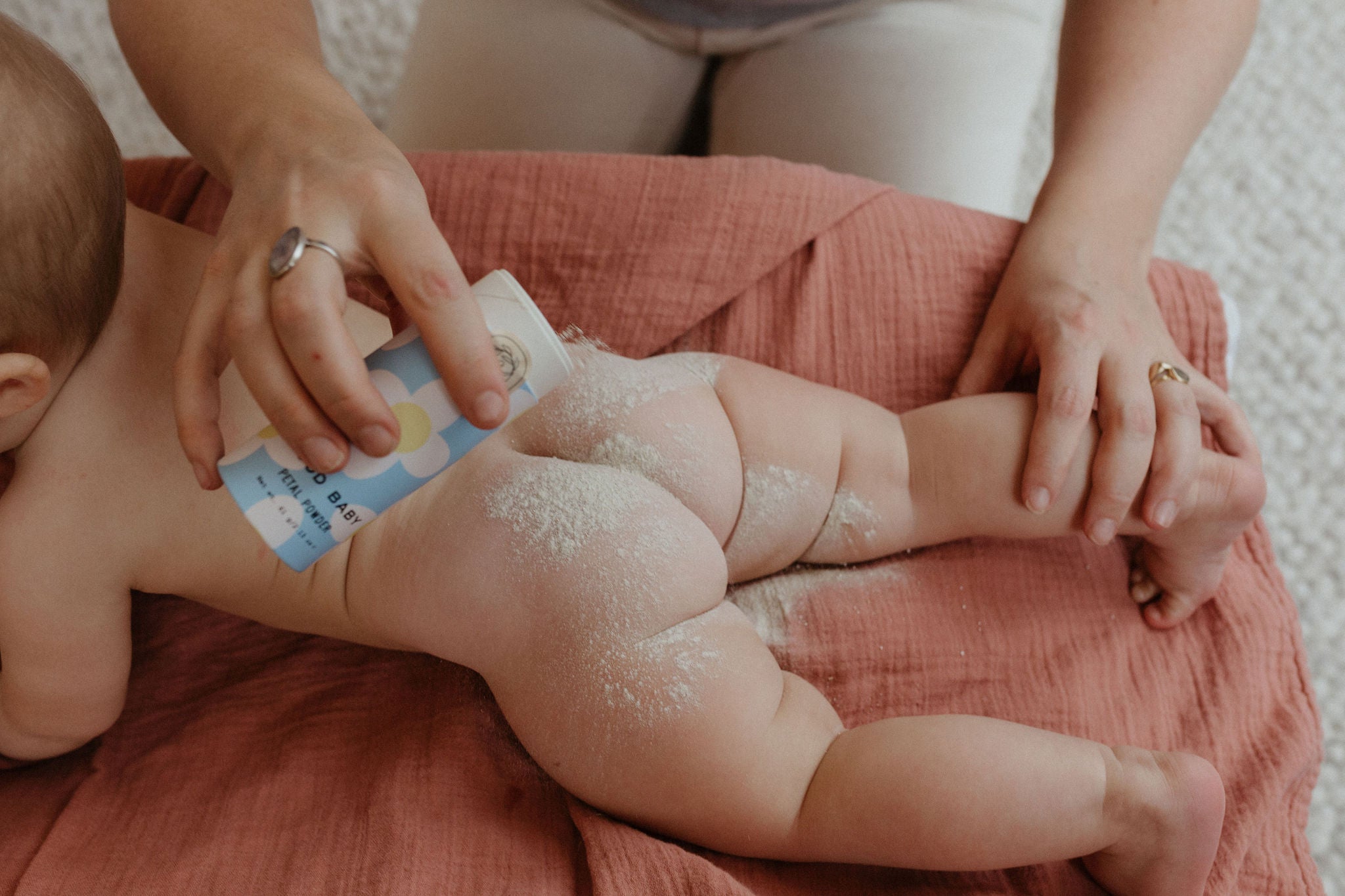 Cute baby applying Organic herbal baby powder in biodegradable tube - talc & cornstarch free by Good Flower Farm