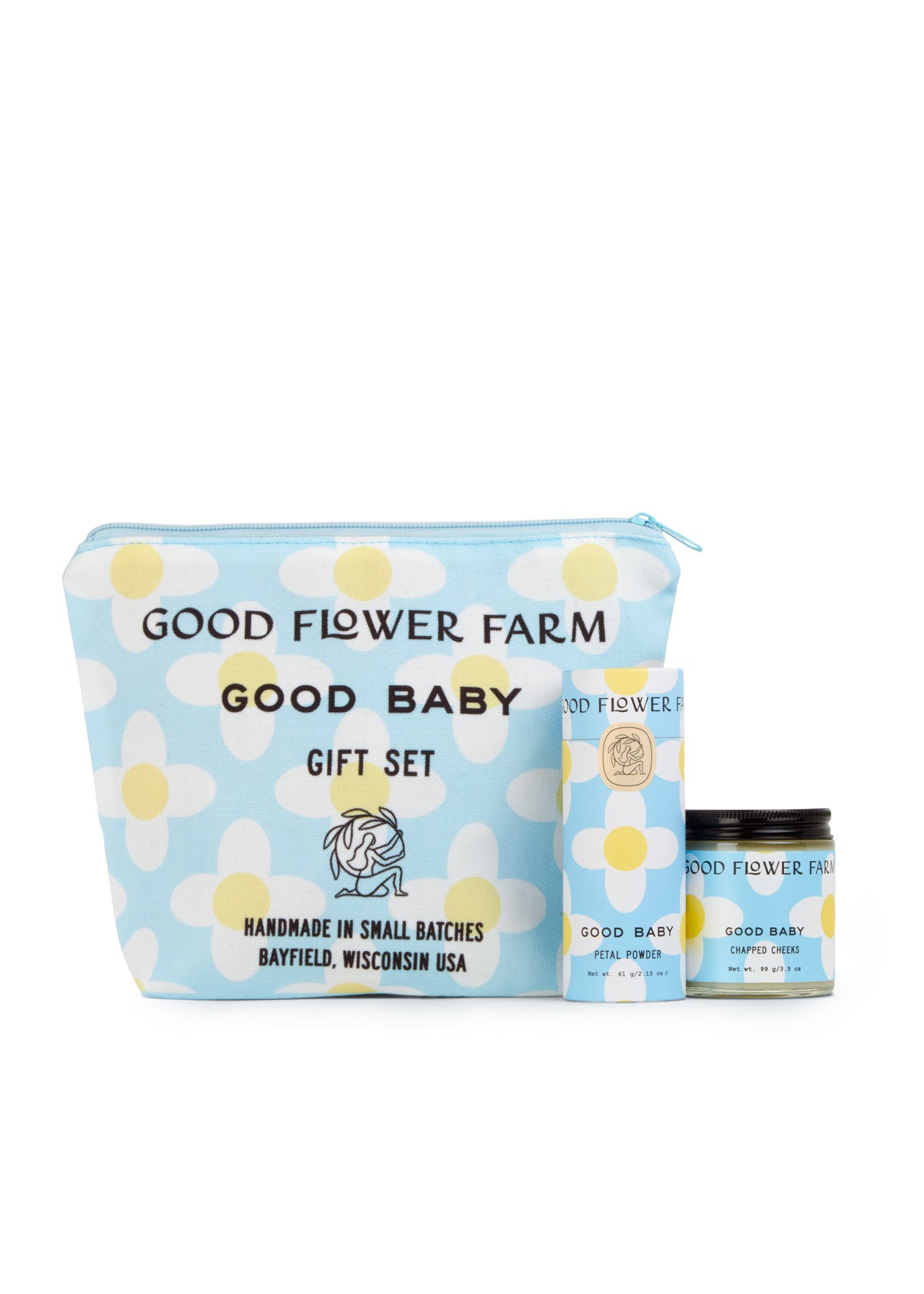 The Good Baby Gift Set by Good Flower Farm includes a blue cosmetic bag with white and yellow floral designs, plus a matching box and jar, featuring baby diaper balm made with gentle botanical ingredients.