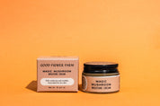 A jar and box of Good Flower Farm Magic Mushroom Moisture Cream sit on an orange background. This skincare is made for dry skin, featuring cordyceps oil and adaptogenic maitake, as highlighted on the packaging.