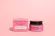 A jar and box of Good Flower Farm Rose Geranium Face Cream are shown on a pink background. The pink containers with black text highlight this moisturizing cream for combination skin, featuring aloe vera and evening primrose oil.