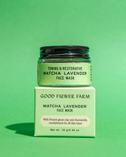 A jar of Good Flower Farm Matcha Lavender Botanical Face Mask made with French green clay sits on its matching green box—both labeled as toning, restorative skincare for all skin types—set against a solid green background.
