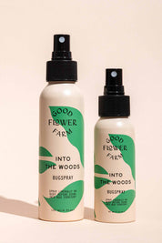 Two bottles from the good-flower-farm Seasonal Skincare Bundle are shown—one large and one small—with green leaf designs on a beige background. Both feature black spray tops and product details on their labels.