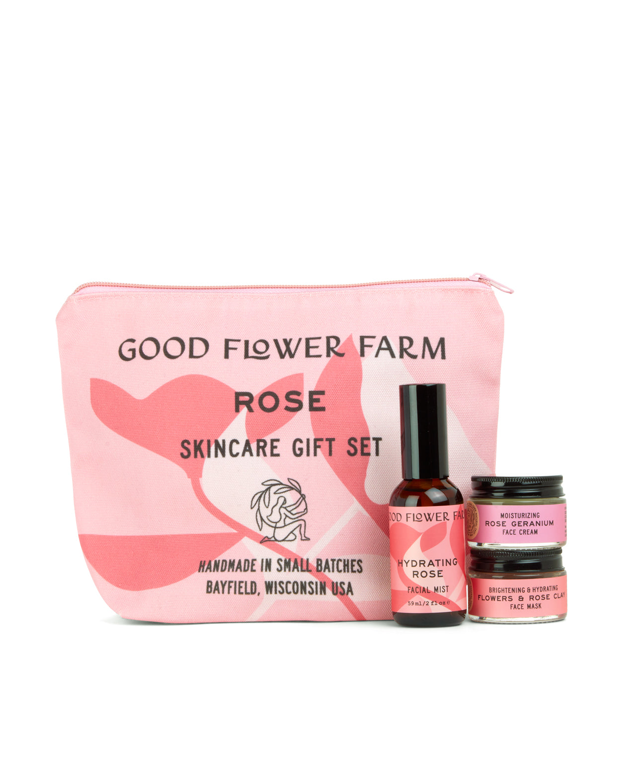 A pink Good Flower Farm Rose Skincare Gift Set cosmetic bag stands behind three floral essentials: Hydrating Rose Facial Mist, Brightening Rose Cream, and Nourishing Face Mask.
