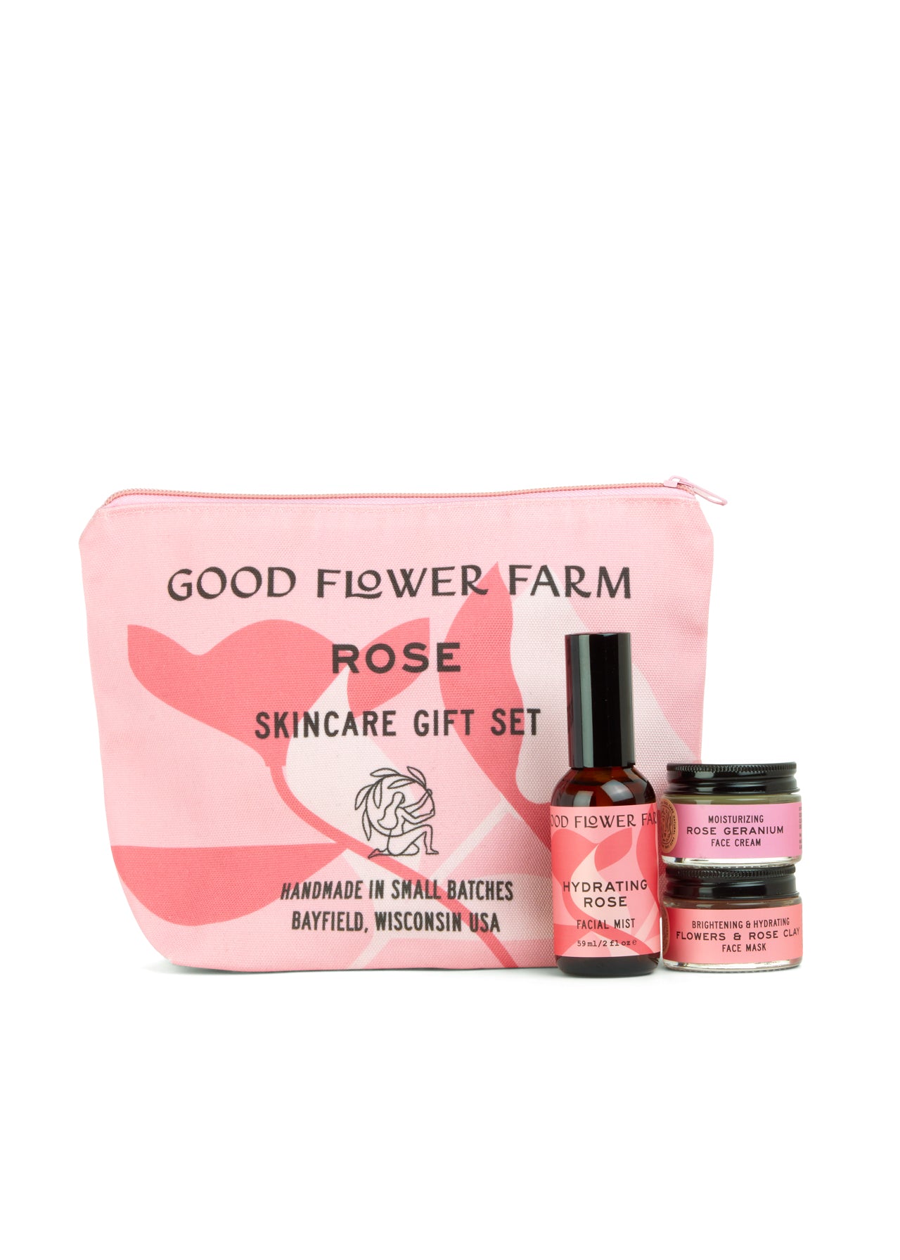 A pink Good Flower Farm Rose Skincare Gift Set cosmetic bag stands behind three floral essentials: Hydrating Rose Facial Mist, Brightening Rose Cream, and Nourishing Face Mask.