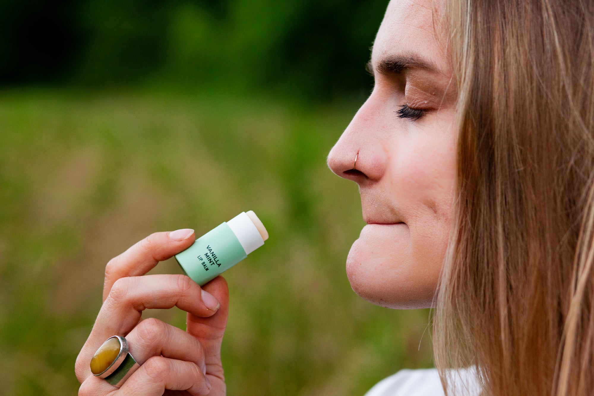 Woman applying Organic vanilla mint lip balm in biodegradable plastic-free tube