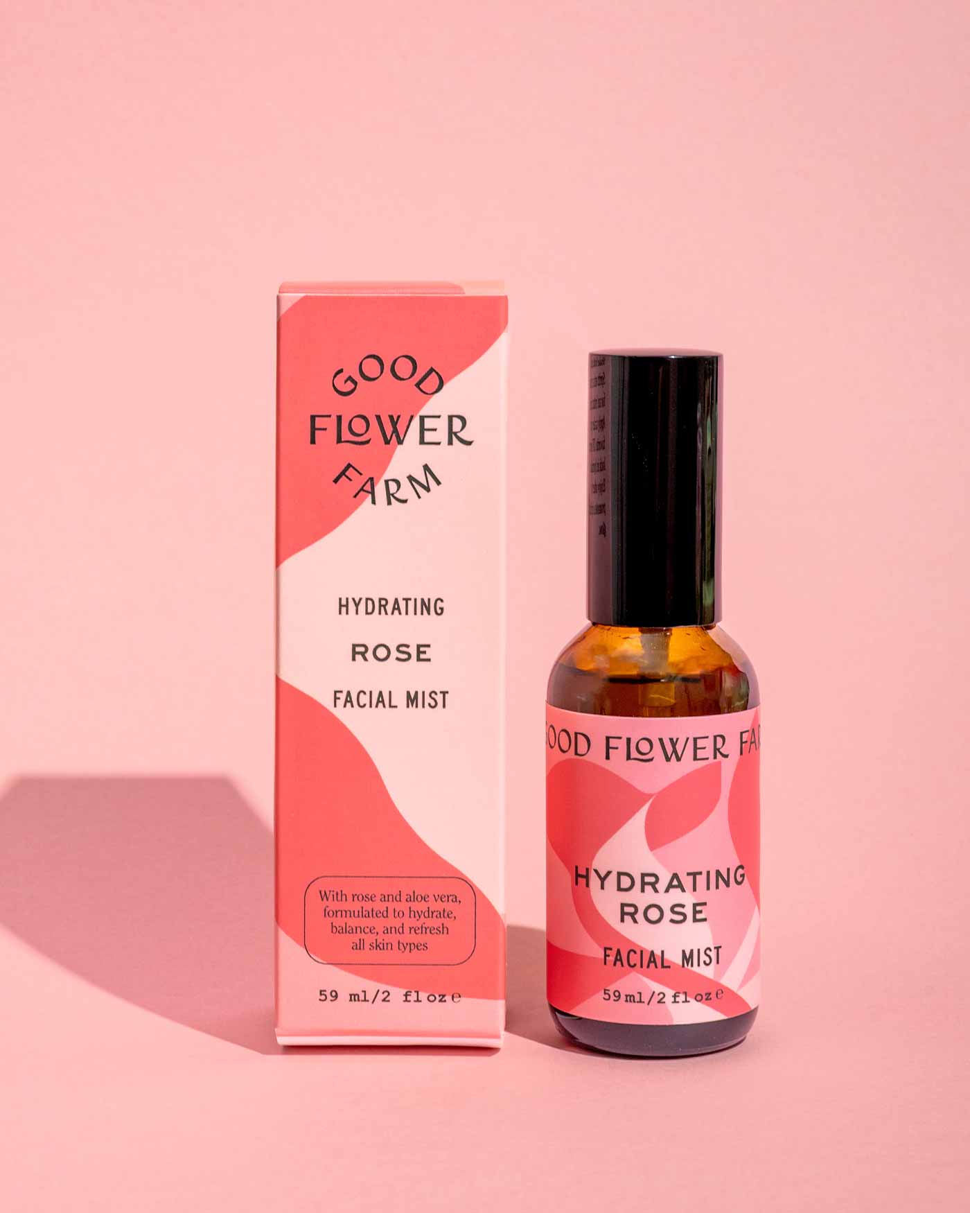 A pink bottle and box from the good-flower-farm Seasonal Skincare Bundle are displayed on a pink background, with a shadow to the left.