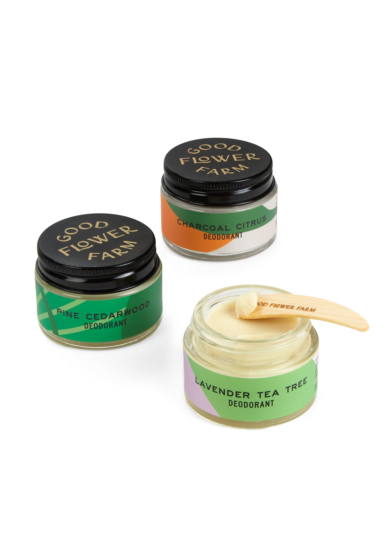 A jar of Good Flower Farm Charcoal Citrus Deodorant with bamboo applicator, featuring creamy, aluminum-free formula thats gentle on sensitive skin. One jar is open, showing the smooth texture and natural ingredients.