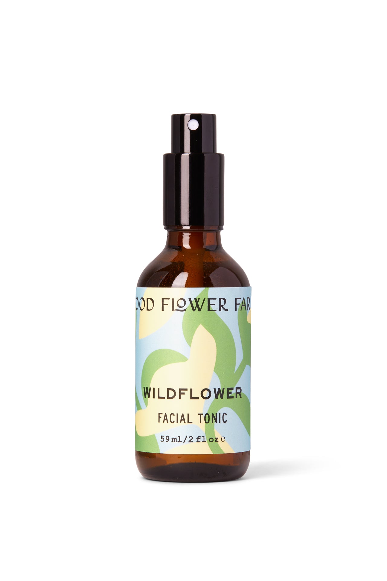 A 59ml (2 fl oz) brown glass spray bottle of Good Flower Farm’s Wildflower Facial Tonic, featuring a green and yellow floral label. This balancing toner is crafted with wild herbal flowers to nourish your skin.