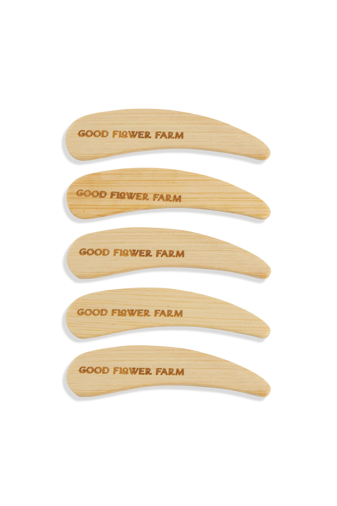 Set of 5 or 10 Good Flower Farm Reusable Bamboo Spatulas, engraved with the brand name, are neatly stacked on a white background—ideal as deodorant applicators or for other personal care uses.
